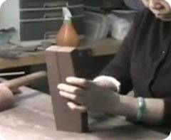 Мастер разрезает кусок с глиной